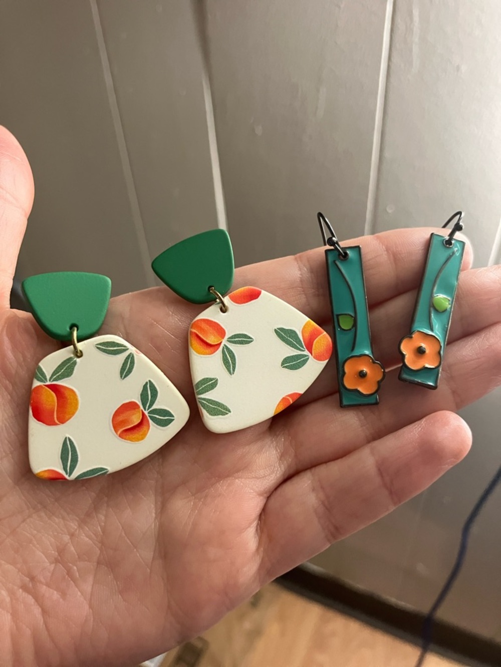 Two sets of orange dangle earrings